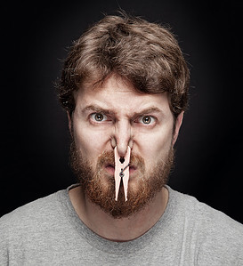 Bad smell concept - peg on male nostrils over black moldy odors moldy sauces