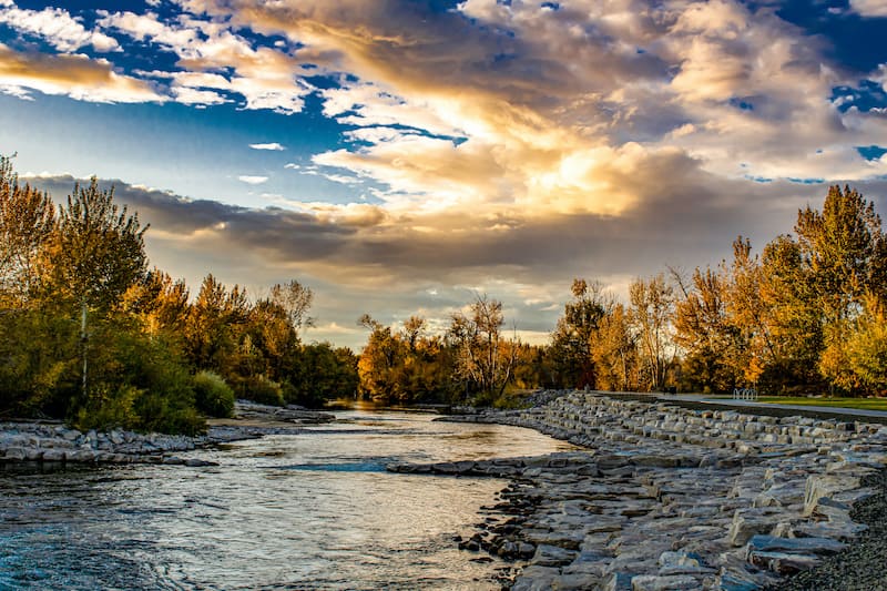 The Boise River runs through a park at sunset in an autumn setting.