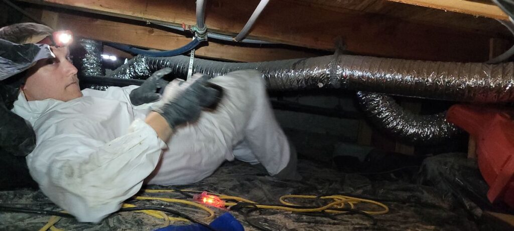 Fixing a broken pipe in a Meridian crawl space