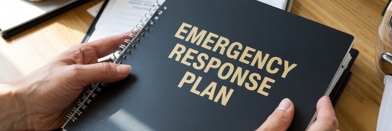 Black book titled "Emergency Response Plan" sits on a table.