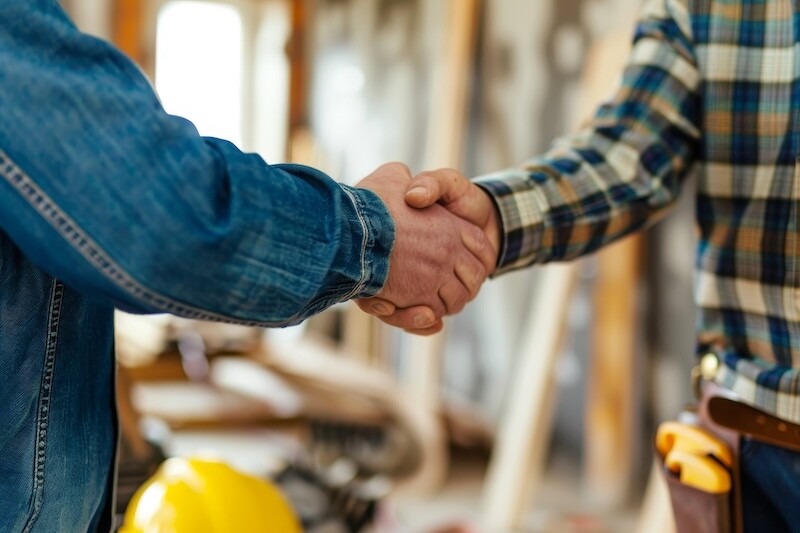 Home renovation agreement. happy homeowner shaking hands with contractor for remodeling project