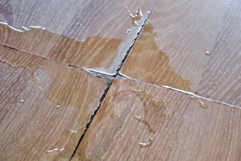 Close-up a wooden laminate in an apartment or house damaged by spilled water from flooding or an accident.