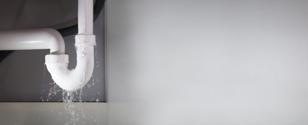 Close-up Of Water Is Leaking From The White Sink Pipe