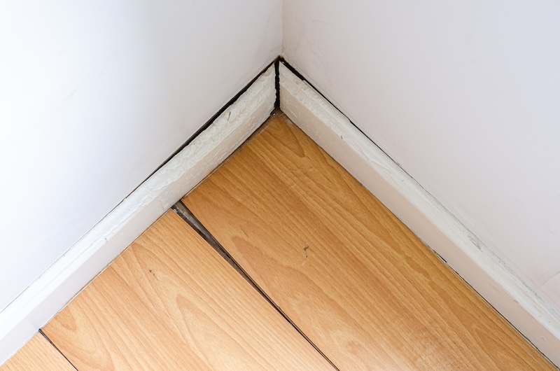 Parquet or wooden floor in the room with floor damaged by destructive elements from moisture or water.