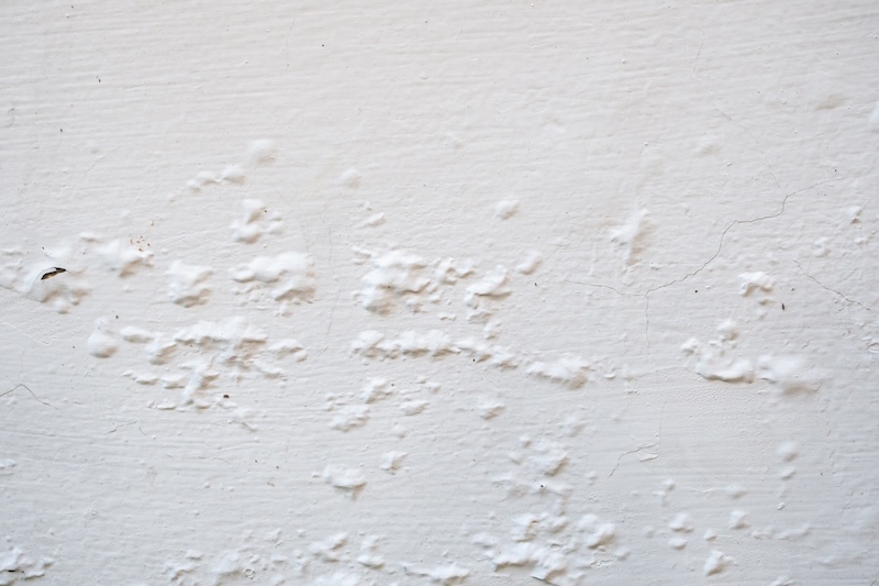 Peeling and Bubbling White Paint on Concrete Wall Texture Background